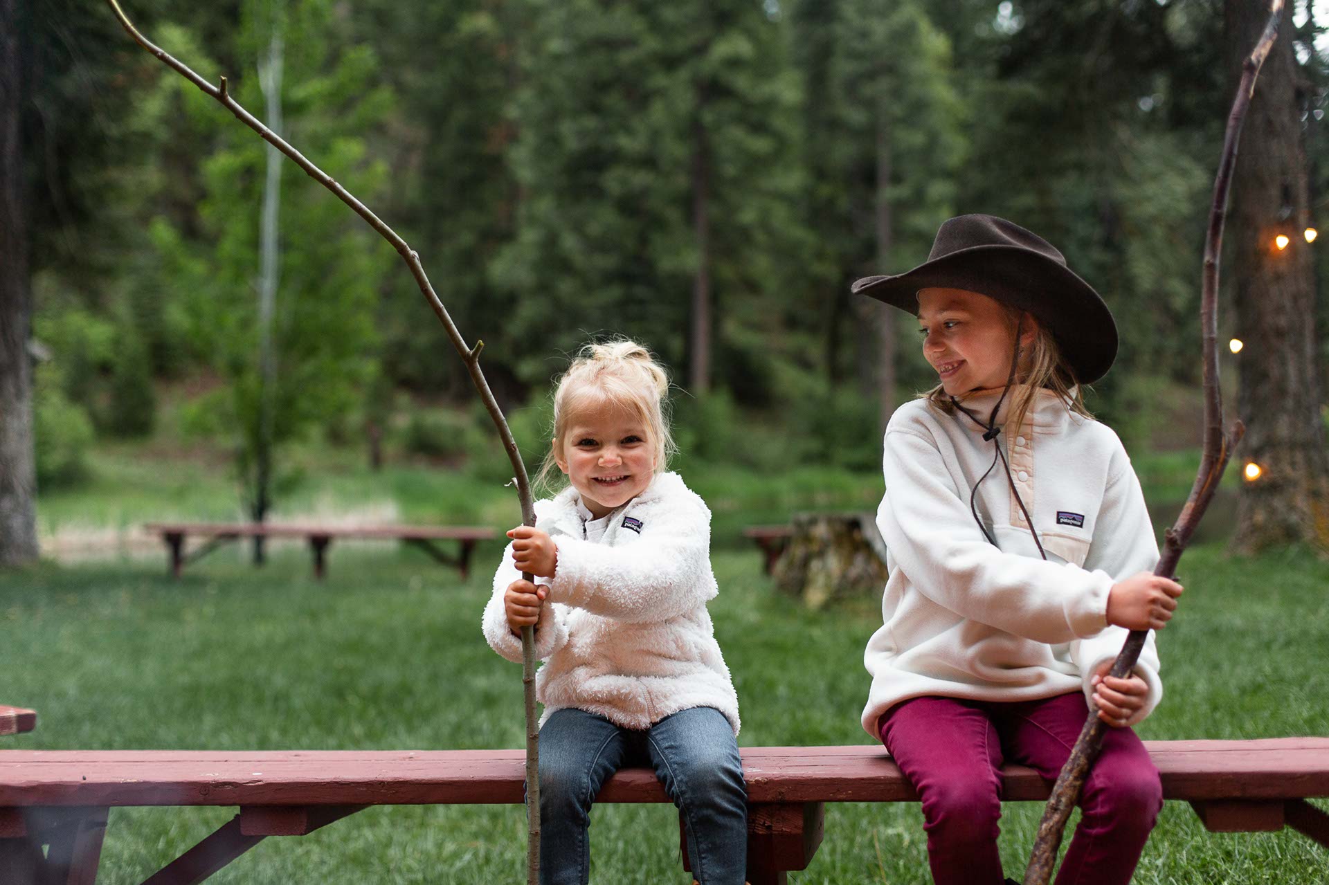Two young girls roasting marshmallows at the campfire