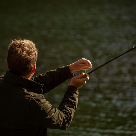 A guest at Greenhorn Ranch fly fishing in the trout pond